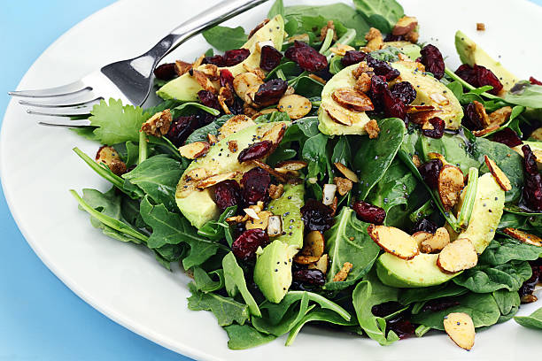 "Healthy spinach and arugula salad with cilantro, dried cranberries, spiced almonds and avocados served with a lite vinaigrette.For the vertical version see"