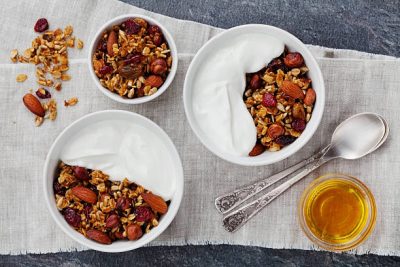 Homemade yogurt bowl with granola on black table, healthy and diet breakfast, top view