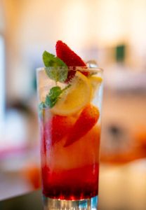 Background image with Mojito cocktail with strawberry, ice and mint
